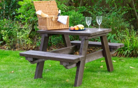 1m-Brown-Table-with-picnic-1 Small brown picnic table on grass with a picnic hamper, food and wine glasses set on it