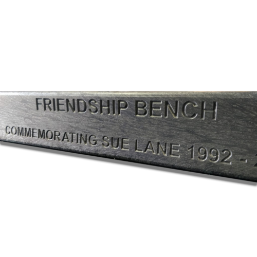 Commemorating engraving in park bench in black recycled plastic slat