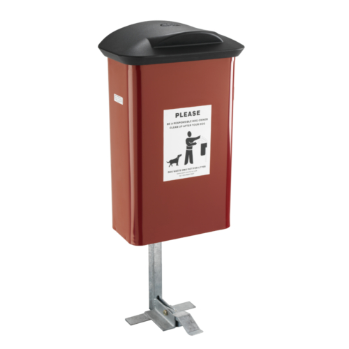 Red dog waste bin with a black lid and Please be a responsible dog owner sticker on the front. Attached to a silver post with a pedal for opening/