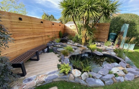 Modular-Bench-At-Garden Garden bench on decking by pond.