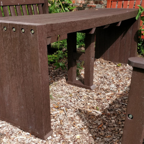 Brown recycled plastic outdoor table on woodchip