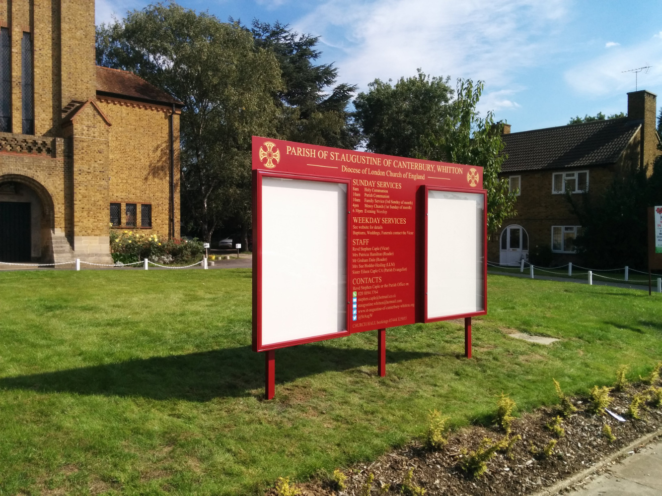 Large church notice board in front of church on a grass verge