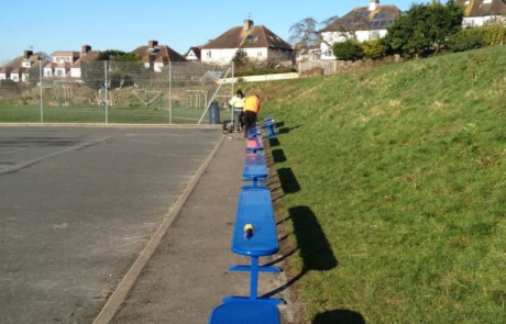 Ranger-bench-Vardeen-School-1 Line of blue steel benches in a school playground