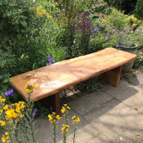 Rustic style oak bench set in a country garden