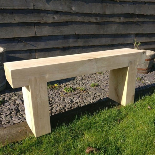 Pale coloured oak bench in a garden