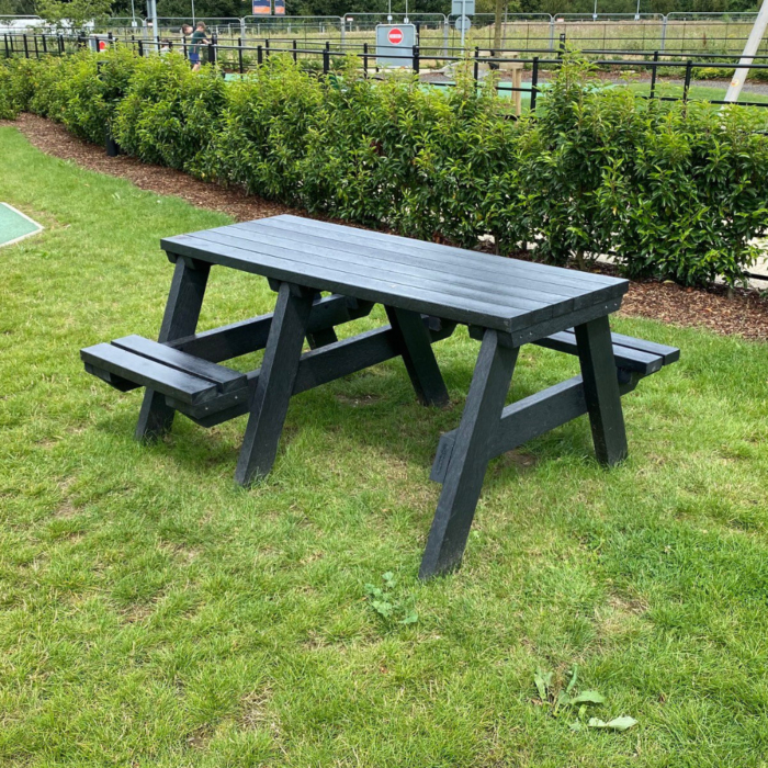 Black recycled plastic picnic table set in grass with room for a wheelchair