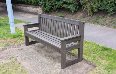 Plastic park bench installed by path