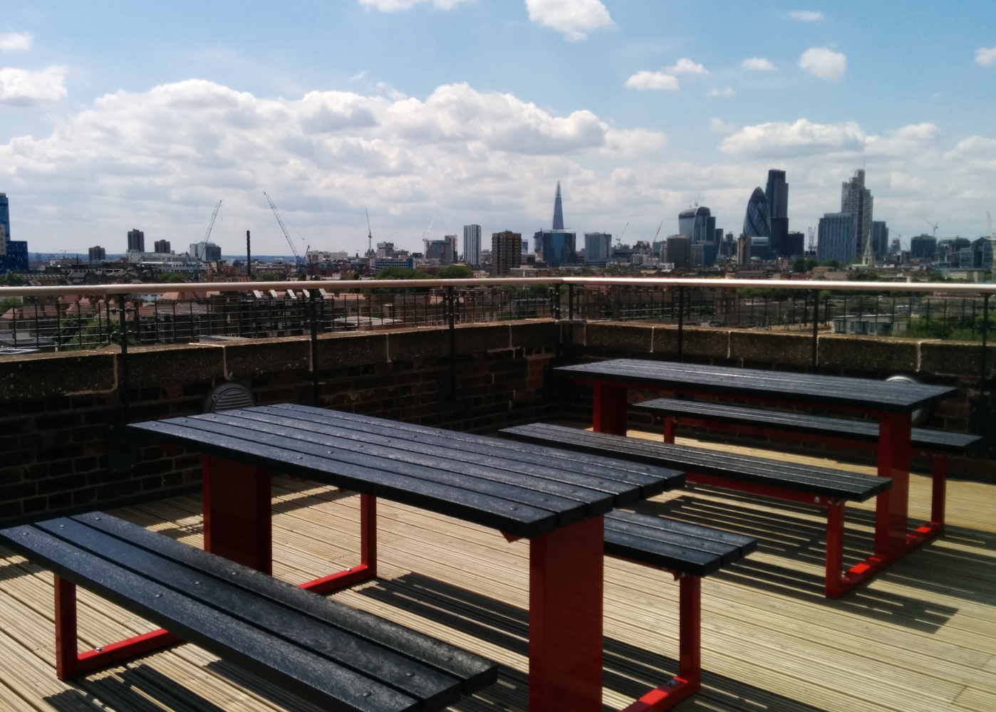 Red and black picnic tables on a London roof terrace