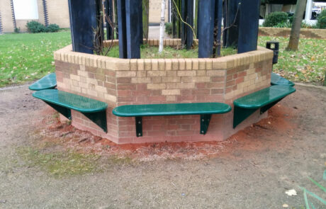 Green steel benches attached around a hexagonal wall
