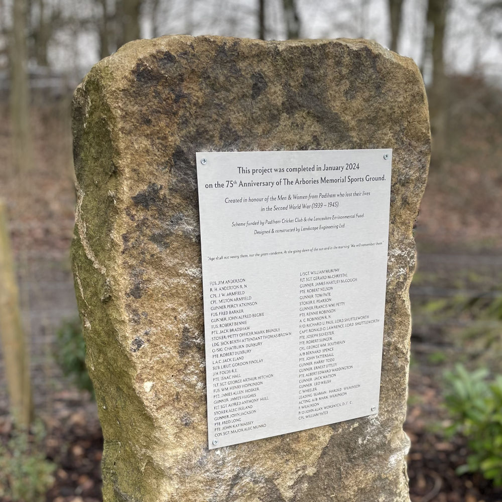 Stainless outdoor remembrance plaque mounted to stone monolith.