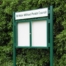 Green framed notice boards on posts with header board showing parish name in green writing
